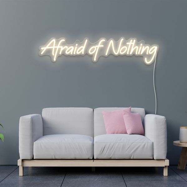 Afraid of Nothing pre-designed CUSTOM NEON® sign shown in warm white on light grey wall above a couch