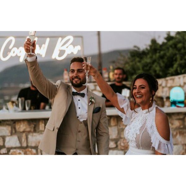 Cocktail Bar Neon Sign shown behind the bride and groom at a wedding - photo from CustomNeon.com.au