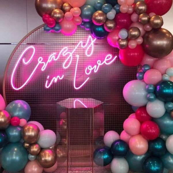 Crazy In Love Wedding Sign in brilliant LED neon flex shown in pink with balloons - photo from Custom Neon @customneon