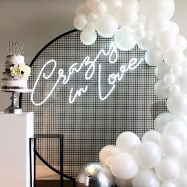 Crazy In Love Wedding Sign in brilliant LED neon flex shown in white with balloons and a wedding cake - photo from Custom Neon @customneon