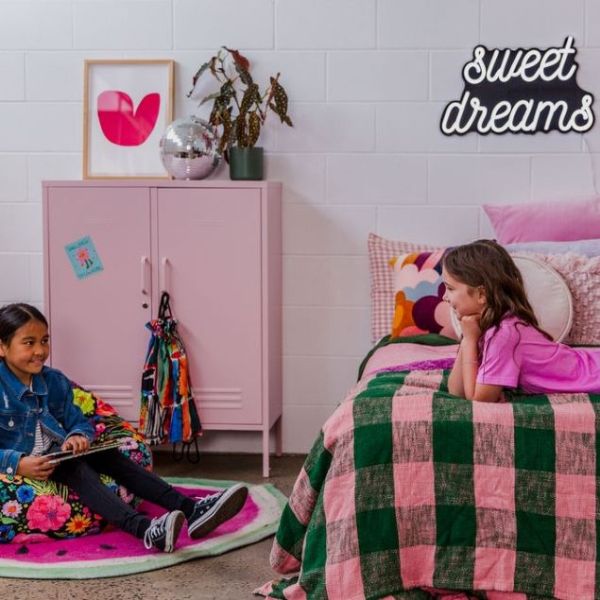 Sweet Dreams CUSTOM NEON® white and black sign on a white wall in a girl's room surrounded by pink decor