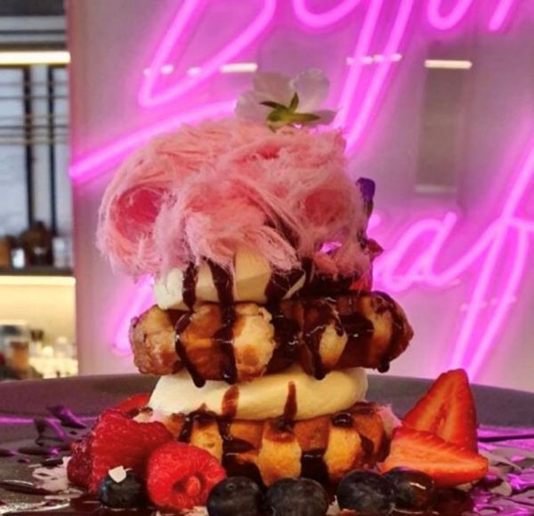 Waffles with Persian fairy floss in front of a pink Death Before Decaf sign @skullandrosecafe by Custom Neon
