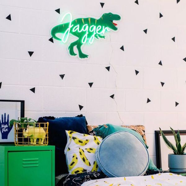 Personalised name sign in LED neon with dinosaur background shown in child's room - from Custom Neon by Neon Collective