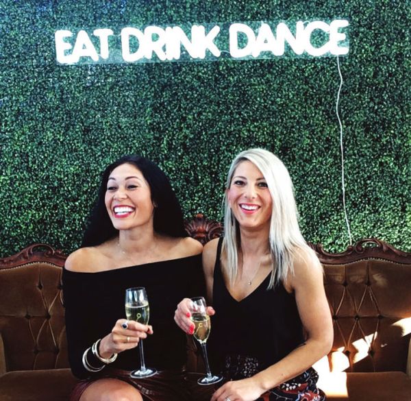 * Eat Drink Dance * Portable LED Neon Light Sign shown on a green wall at an Event - photo from CustomNeon.com.au