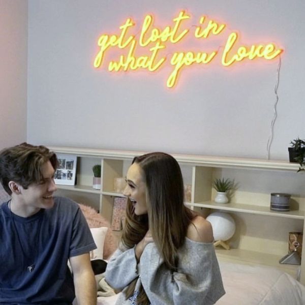 Get Lost in What You Love yellow LED neon sign shown as bedroom decor - photo from Custom Neon (formerly Neon Collective)