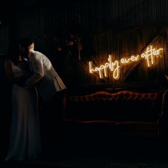 Happily Ever After light sign on a wooden wall above a vintage sofa - from Custom Neon®