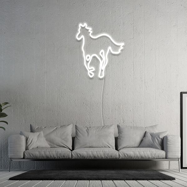 White LED neon horse light on grey textured wall above a sofa in a modern living room - by Custom Neon®
