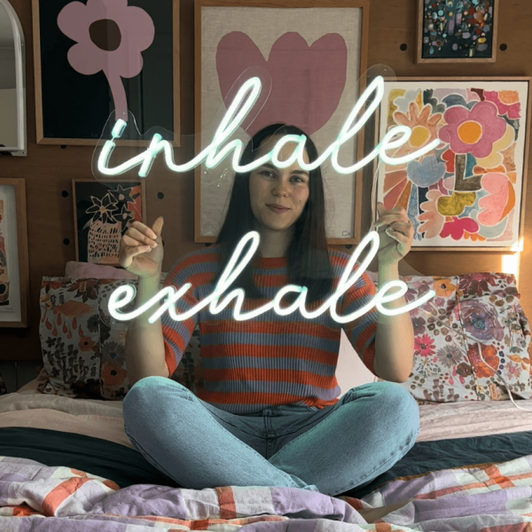 Custom Neon® Inhale Exhale sign shown in a bedroom