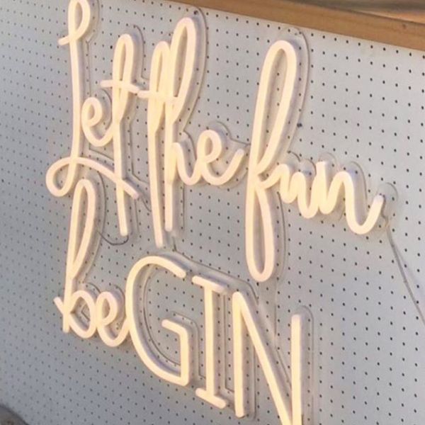 Let the Fun beGIN large neon sign - shown attached to the front of a gin bar at an event - photo from CustomNeon.com.au