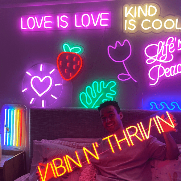Custom Neon® signs and artwork mounted above a bed