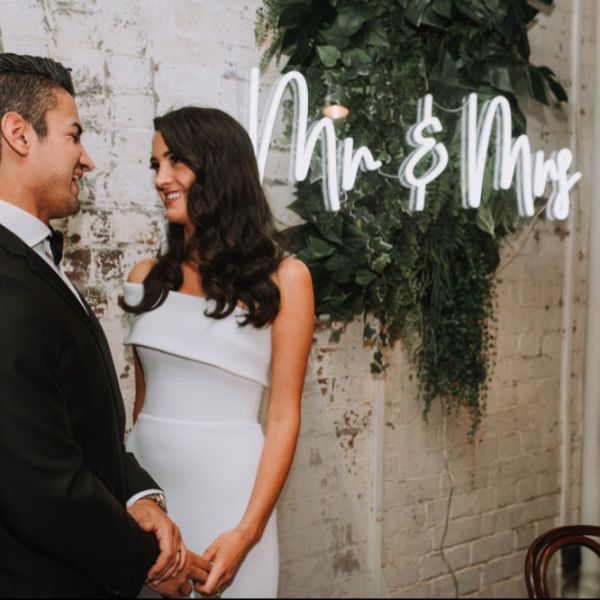 Mr & Mrs portable LED neon sign on clear acrylic backboard. Shown on exposed brick wall. - Photo Custom Neon by Neon Collective