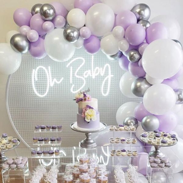 Oh Baby baby shower sign shown surrounded by balloons and cakes - photo from Custom Neon by Neon Collective