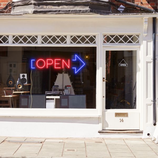 Neon light open sign in red with an oversized blue arrow shown in a shop window - from CustomNeon.com.au