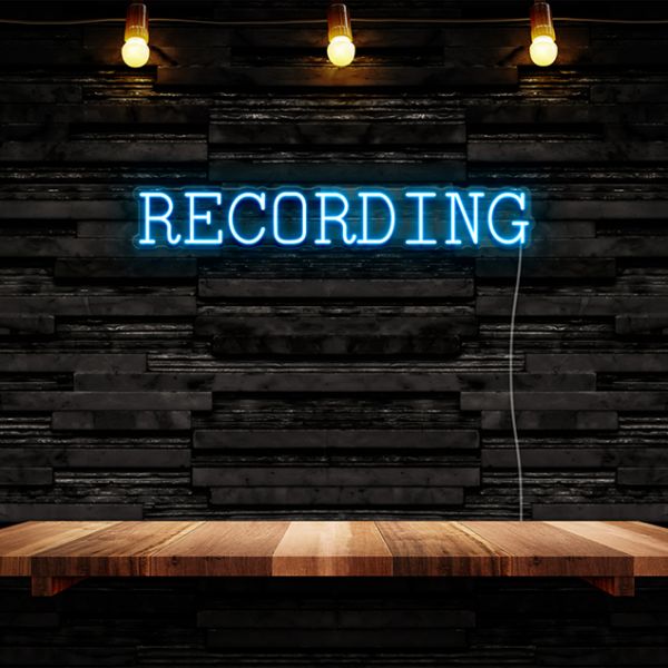 CUSTOM NEON® electric blue Recording light in a serif font against a dark wall