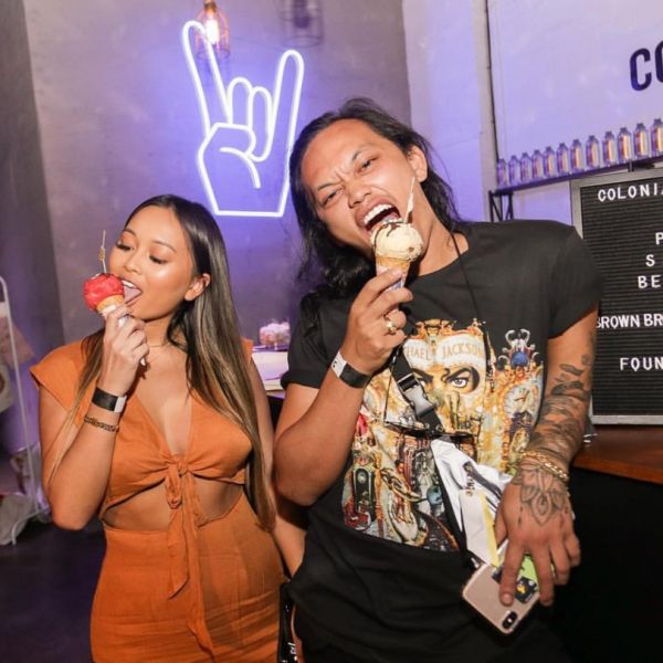 Rock On Emoji LED Neon Sign shown in white, mounted on the wall of a store - photo from Custom Neon by Neon Collective
