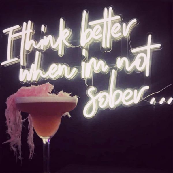 I Think Better When I'm Not Sober LED neon bar sign shown with cocktail - photo from Custom Neon by Neon Collective