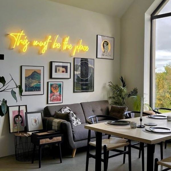 This Must be the Place Custom Neon® feature wall sign @our_build_our_journey,This Must be the Place yellow Custom Neon® sign on a feature wall in a living/dining room @our_build_our_journey