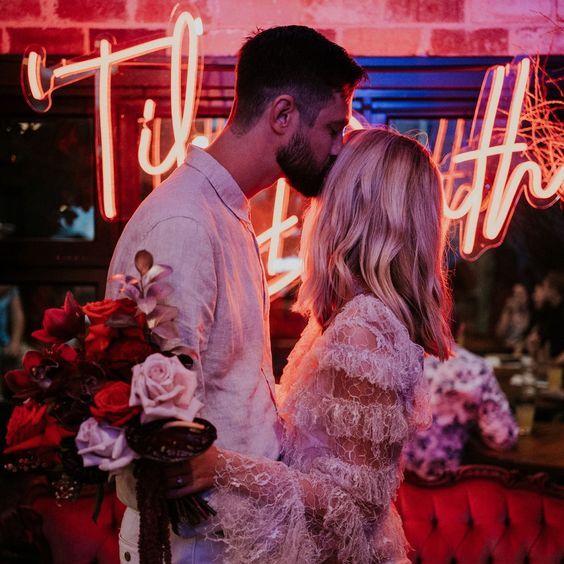 Til Death LED neon sign shown behind the happy couple at a wedding - photo from CustomNeon.com.au @customneon