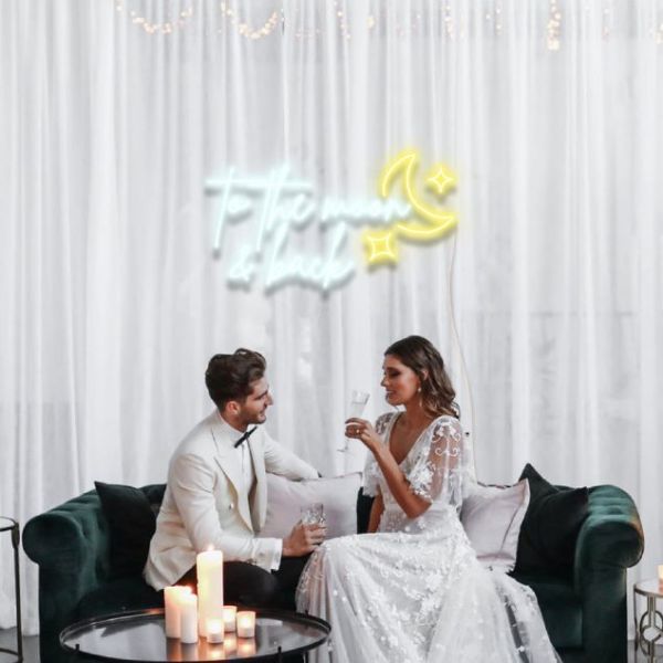 To the Moon & Back LED neon sign mock up with a moon & stars shown at a wedding - from CustomNeon.com.au