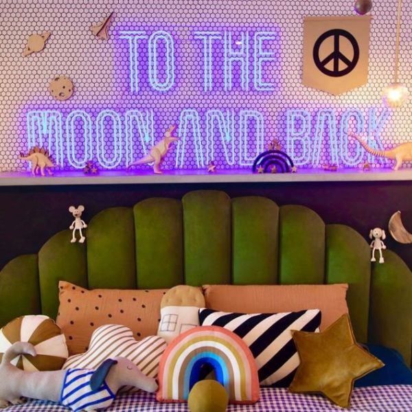 To The Moon And Back neon sign shown in Marquee font in a child's bedroom from Custom Neon™