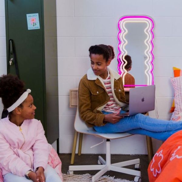 Pink LED Neon Squiggly Mirror by  CUSTOM NEON® in a girl's bedroom turned on