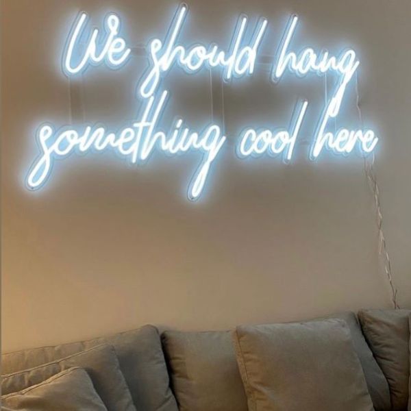 We Should Hang Something Cool Here white light sign shown on living room wall - made by Custom Neon