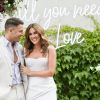 Large All You Need is Love white LED neon sign shown on frame at  wedding of @georgiealove & @leeroyelliot - made by Custom NeonÂ®