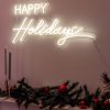 CUSTOM NEON® Happy Holidays warm white LED neon sign wall-mounted next to a Christmas tree