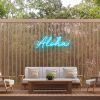 Custom Neon® Aloha sign in tropical blue on a wooden screen in an alfresco entertainment area.