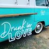 Drunk in LOVE LED Neon Light Sign for Weddings, Bars & Home Decor shown on bar van at an event  - photo Custom Neon by Neon Collective