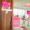 Kiss Me A Lot Everywhere LED Neon Sign shown hung from the entrance to a Valentine's Day event - photo CustomNeon.com.au