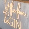 Let the Fun beGIN large neon sign - shown attached to the front of a gin bar at an event - photo from CustomNeon.com.au