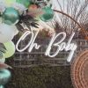 Oh Baby white LED neon light styled outdoors with a floral balloon arch - made by @customneon for @effortless_elegance_uk