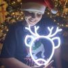 CUSTOM NEON® Reindeer light held by a child with a Christmas decorations in the background