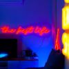 The Best Life red neon flex sign shown above a flatscreen TV in a living room @customneon