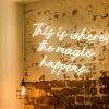 This is Where the Magic Happens faux neon sign in warm white on distressed brick wall @customneon