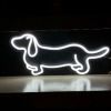 Adorable LED neon sausage dog shown on a table in white - from Custom Neon by Neon Collective
