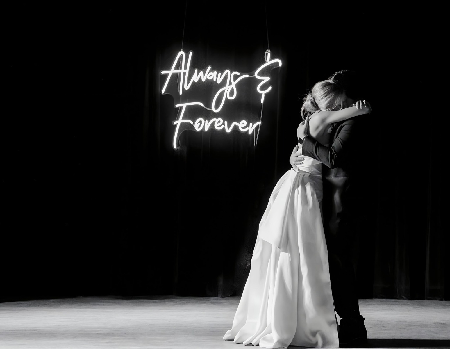 Always & Forever white Custom Neon® wedding sign on a stage behind the newlyweds