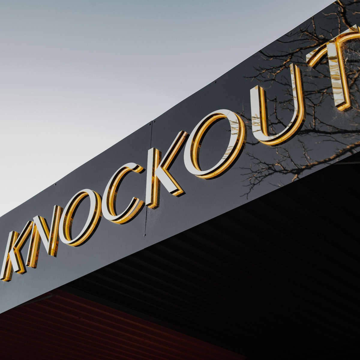 Backlit exterior sign with a mirrored metal face