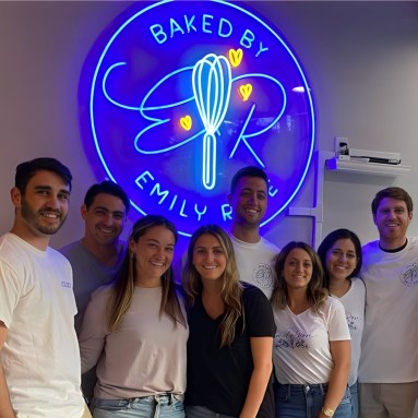 Custom Neon® blue bakery logo on a white wall @baked_by_emilyrose