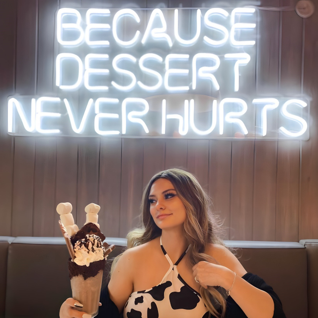 Because Dessert Never Hurts white Custom Neon® sign on dark wood panelled wall @mannysweetreats