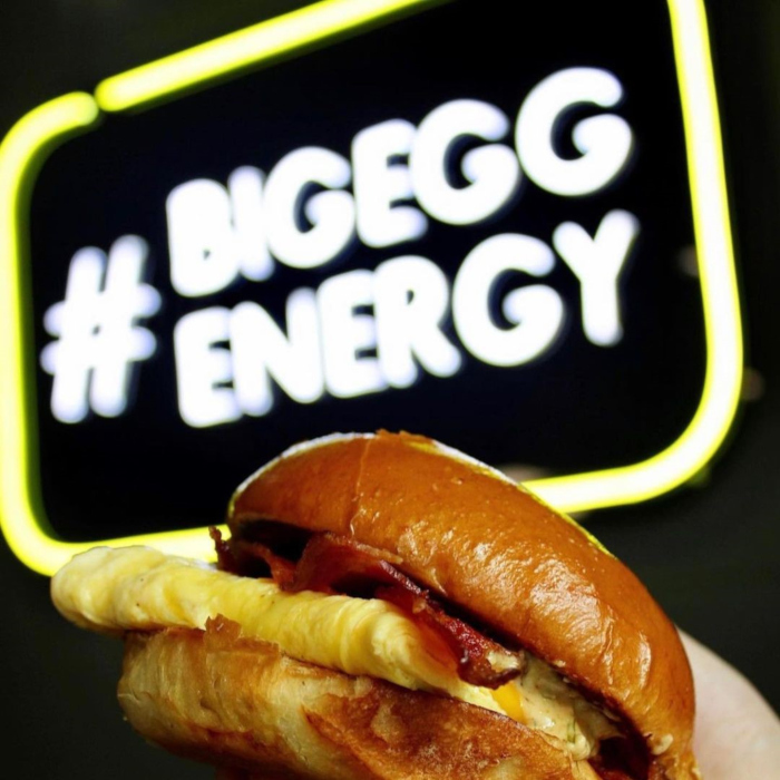 Custom Neon® white and yellow Big Egg Energy hashtag sign on the ceiling @crackedeggery sandwich shop