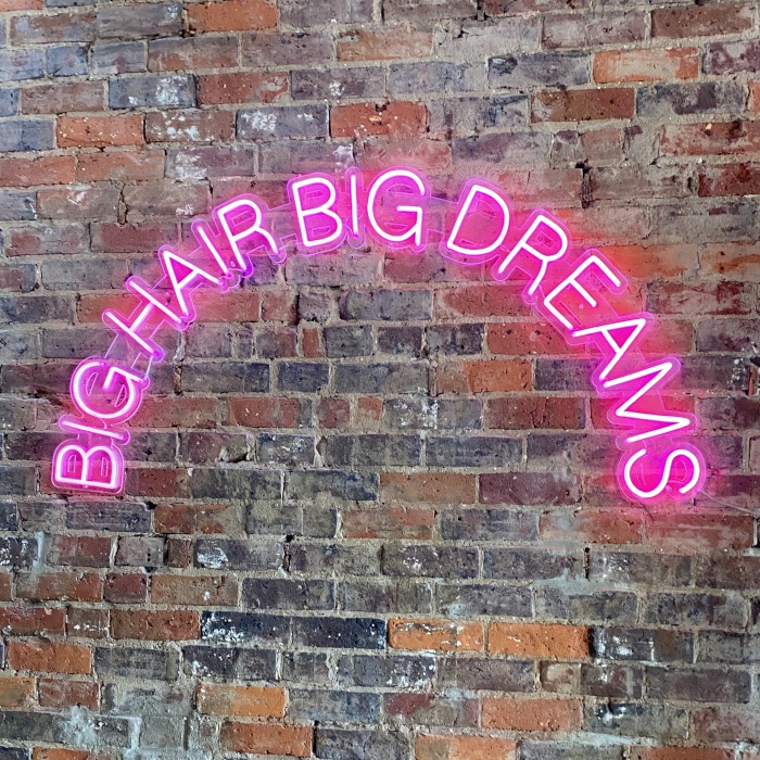 Pink Custom Neon® hair salon sign on a brickwall @blo.out.bar