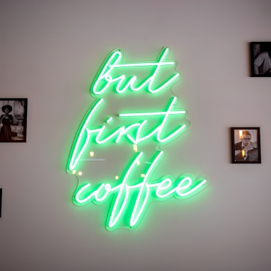 But first coffee bright green Custom Neon® quote sign on feature wall surrounded by framed pictures @pimlottandstrand