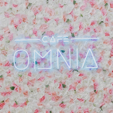 Logo light sign on floral wall @cafeomnia by Custom Neon®