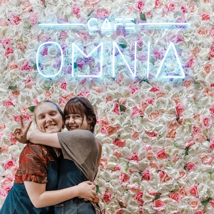 Custom Neon® Logo light sign on a flower wall @cafeomnia