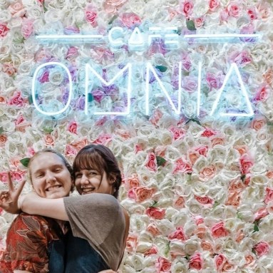 Custom Neon® Logo light sign on a flower wall @cafeomnia