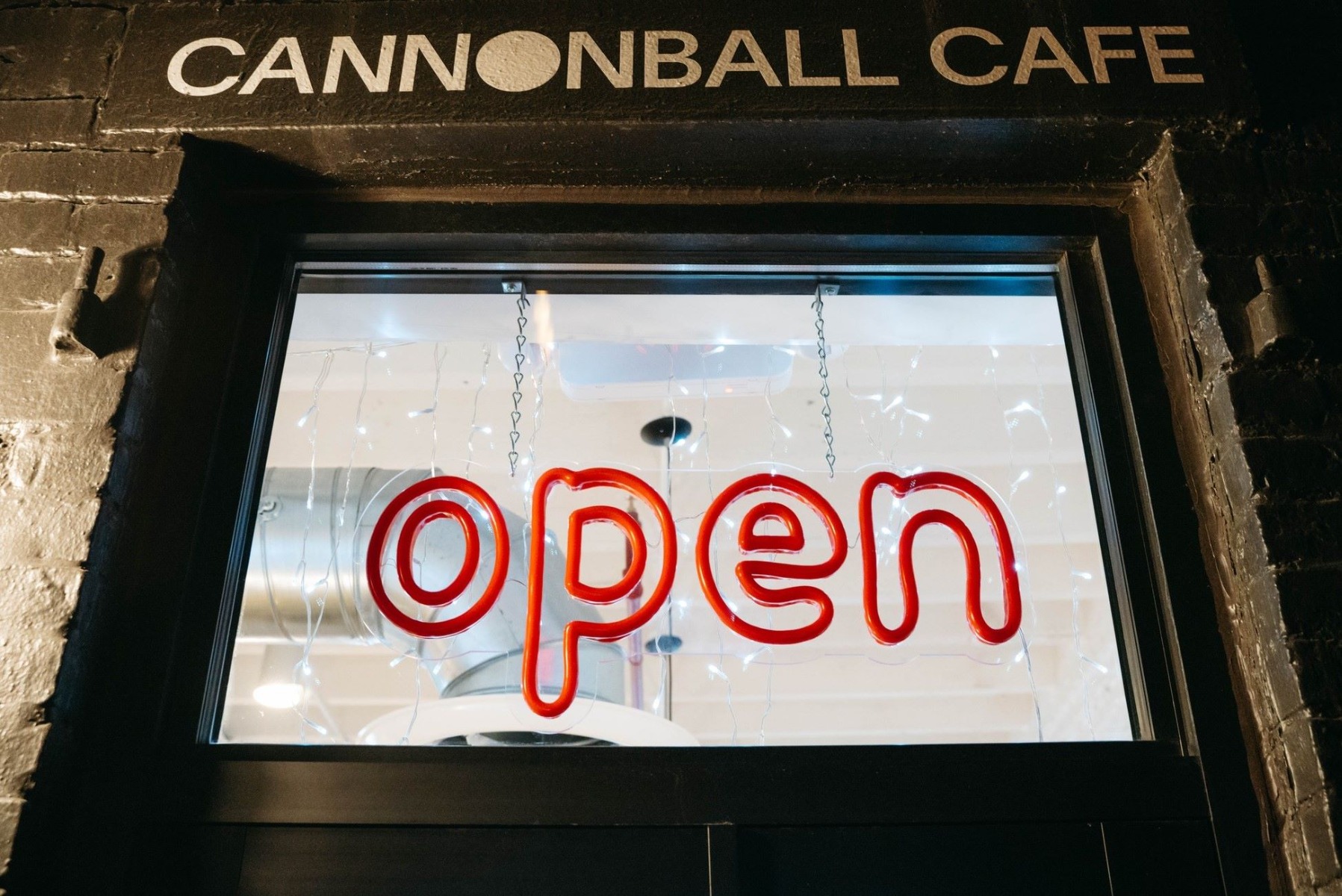 Custom Neon® red OPEN sign in the window @cannonballcafebos