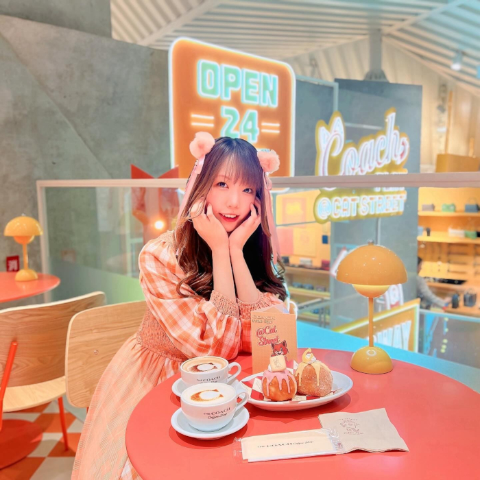 Custom Neon® signs in background of a selfie sign taken in the Coach Cafe at Coach Play @Cat Street @coach_japan photo by @shi0tann