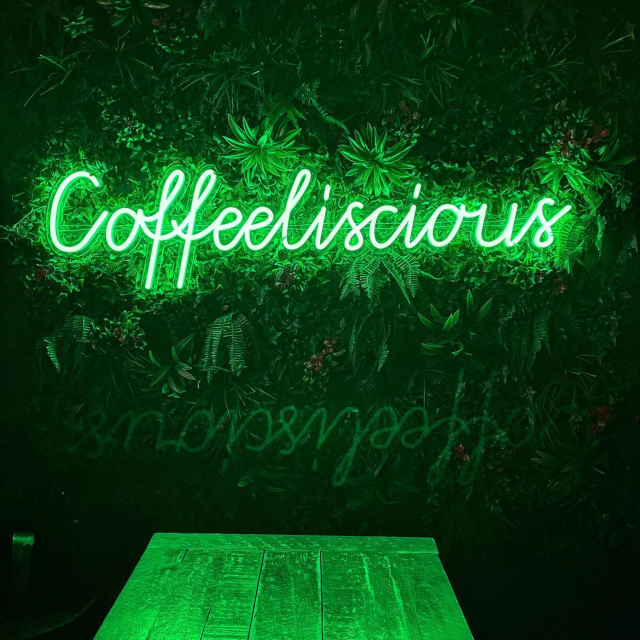 Green Custom Neon® bakery name sign on green wall @coffeeliscious